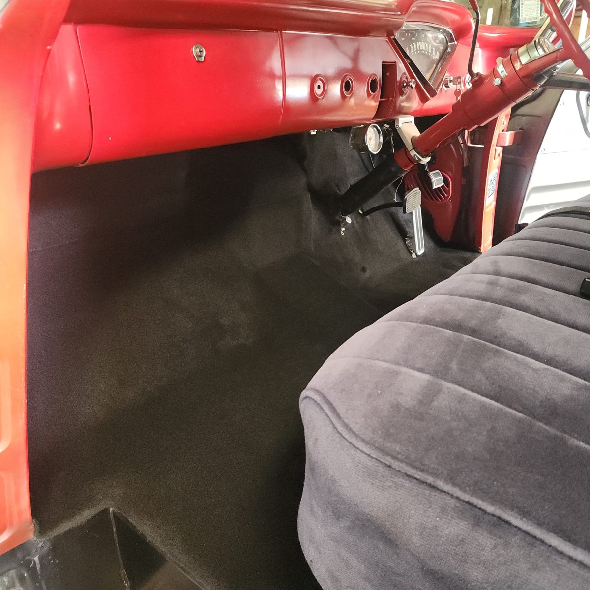 Vintage Ford truck cab after — new black carpet floor with re-covered grey velour bench seat installed