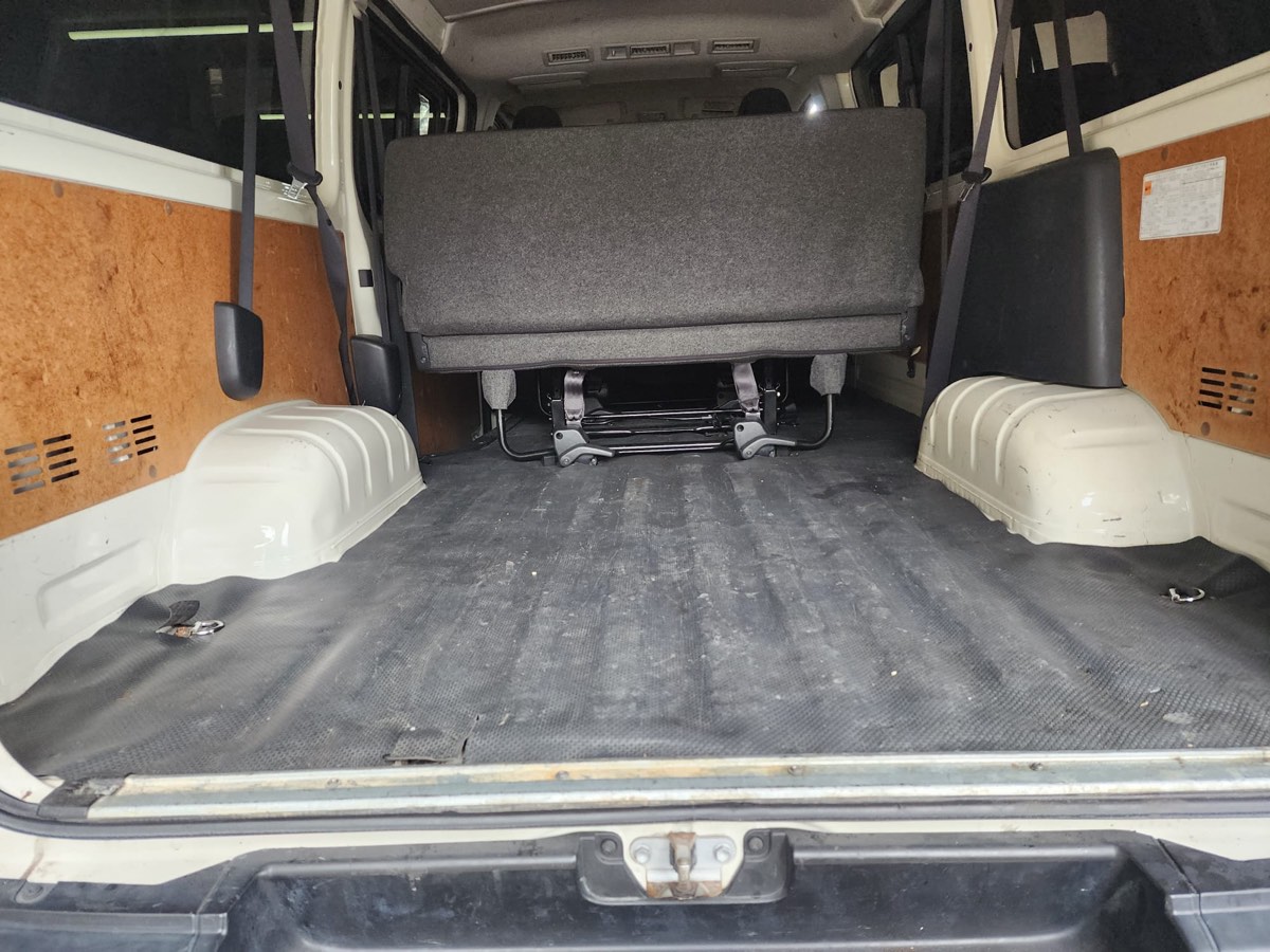 Toyota Hiace cargo van — bare rubber-mat floor and exposed bare side panels before re-trim